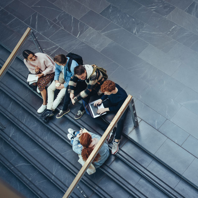 A group of people sitting on top of steps.
